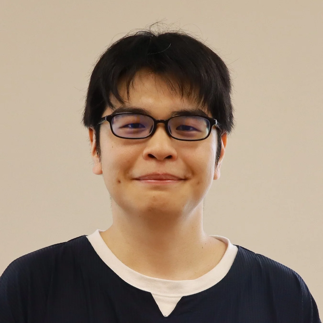 眼鏡をかけた若いアジア人男性のバストアップ写真